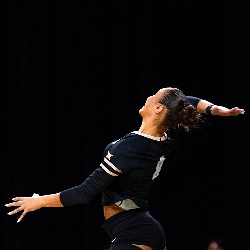 Inés Losada en el aire, de espaldas, con el dorsal 8 y las mangas doradas de la camiseta negra de Colorado