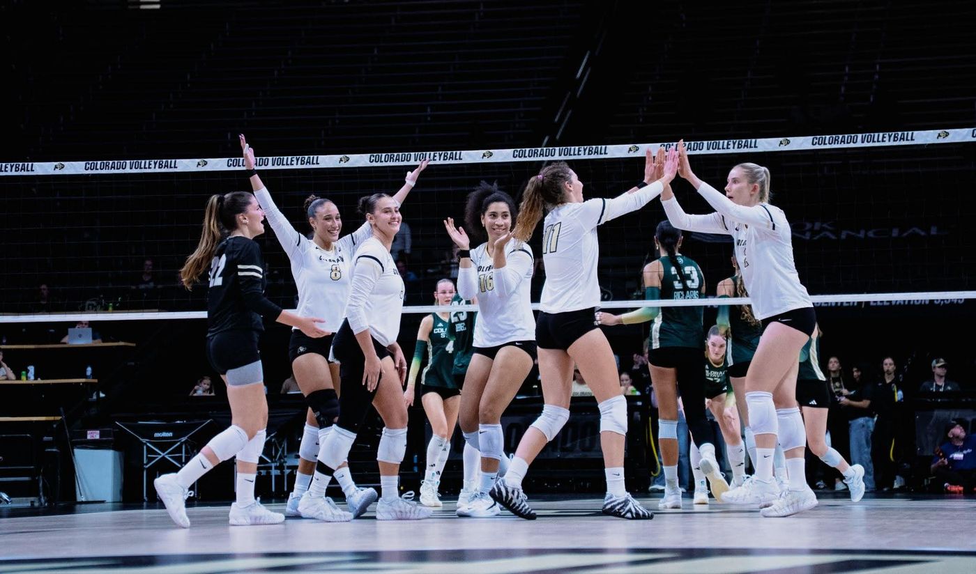 La plantilla de voleibol de Colorado celebrando en la pista